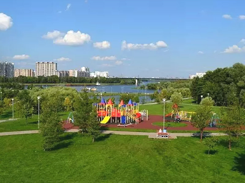 Детская площадка в Братеевском каскадном парке на юге Москвы, газон и резиновая крошка